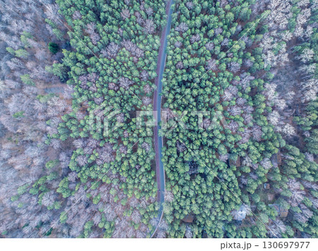 Aerial view of road in beautiful autumn forest at sunset. Beautiful landscape with empty rural road, trees with red and orange leaves. Aerial view of road in beautiful autumn forest at sunset. Beautiful landscape with empty rural road, trees with red and orange leaves. 130697977