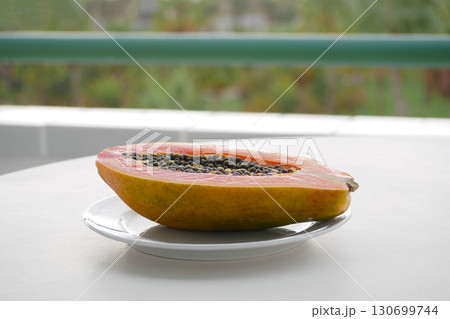 Fresh Ripe Papaya on White Plate at the Outdoor Table 130699744