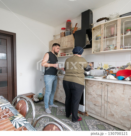 Engaging family moments in a cozy kitchen during a casual afternoon with cooking and conversation in a warm home setting 130700121