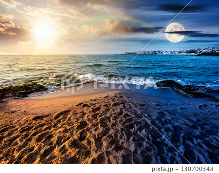 sunrise on a sandy town beach on equinox season. day and night time change concept. beautiful and warm weather on the shores of black sea. coast with sun and moon at twilight 130700348