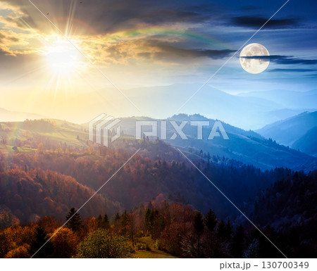 beautiful mountain landscape. day and night time change concept. wonderful countryside scenery on autumn equinox. rural pasture and trees in colorful foliage on rolling hills with sun and moon 130700349