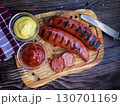Delicious grilled sausages  on wooden  board 130701169