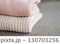 A neat stack of colorful and cozy knitted sweaters. 130703256