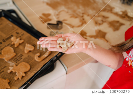 A young girl is cooking homemade Christmas cookies in the kitchen. A young girl is cooking homemade Christmas cookies in the kitchen. 130703279