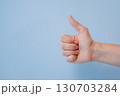 Hand showing thumbs up gesture on blue background with copy space, symbol of approval and success 130703284