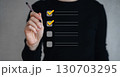 A businessman uses a pen to mark a checkbox for document quality control. 130703295