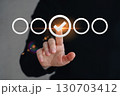 A businessman uses a pen to mark a checkbox for document quality control. 130703412
