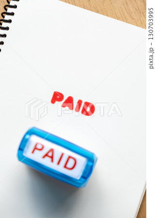 Blue Office Stamp Printing Paid Text on White Paper Blue Office Stamp Printing Paid Text on White Paper 130703995