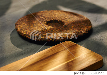 Discovering the rich texture and aroma of puer tea on a wooden board in a serene setting 130704543