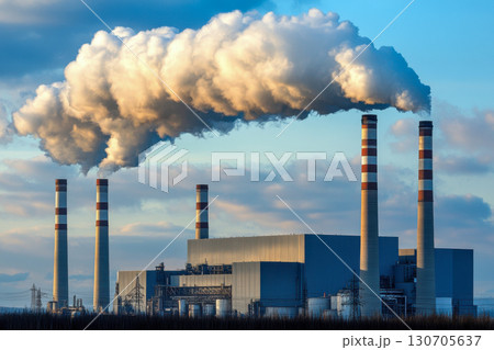 Industrial power plant with tall chimneys releasing thick plumes of white smoke into a dramatic blue sky. Environmental issue of air pollution from energy. 130705637