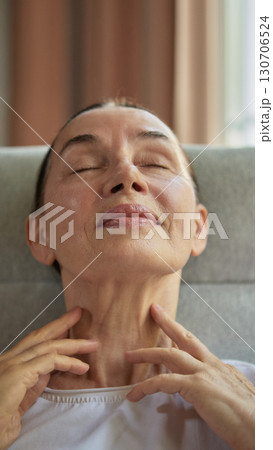 Mature woman massaging neck with closed eyes relaxation Mature woman massaging neck with closed eyes relaxation 130706524
