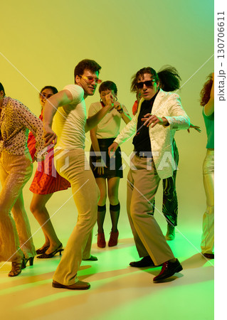 Men in white shirt and blazer leading dance in retro neon party Men in white shirt and blazer leading dance in retro neon party 130706611