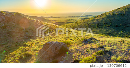 Sunset over green hills and valley, illuminated by the golden sunlight Sunset over green hills and valley, illuminated by the golden sunlight 130706612