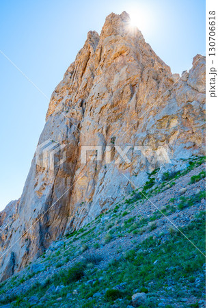 Sun rays break over the rocky peak, creating a majestic contrast of light and stone Sun rays break over the rocky peak, creating a majestic contrast of light and stone 130706618