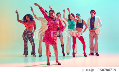 Smiling woman leading dance group with confidence in vibrant studio 130706719