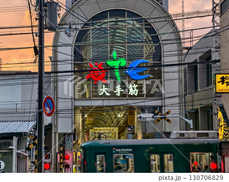 夕暮れ時、京阪電車が通過する伏見大手筋商店街のアーケード入口。京都市、京都府、日本 夕暮れ時、京阪電車が通過する伏見大手筋商店街のアーケード入口。京都市、京都府、日本 130706829
