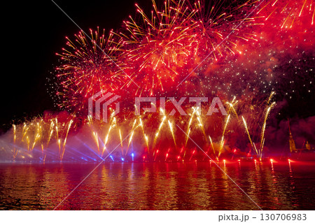 Festive colorful fireworks and illumination in dark sky with beautiful reflection in water. Holiday SCARLET SAILS. High quality photo 130706983