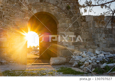 Ruins of ancient Temple of Apollo in Side on sunset. Bright sunbeams in antique arch, Alanya province, Turkey. Ruined old city. Unesco Cultural Heritage Monument. High quality photo 130707027