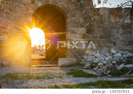 Ruins of ancient Temple of Apollo in Side on sunset. Bright sunbeams in antique arch, Alanya province, Turkey. Ruined old city. Unesco Cultural Heritage Monument. High quality photo 130707031