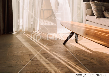 Modern room interior with an open window in minimal style. Transparent tulle with morning sun rays on shadow background. High quality photo 130707125