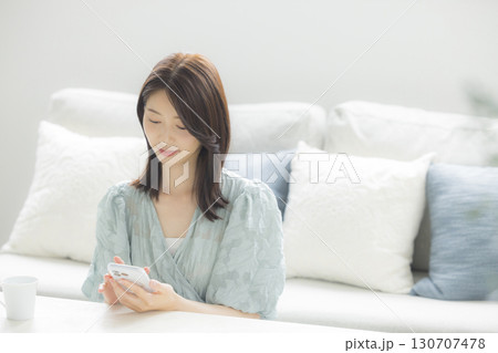 部屋でスマホを見る女性 部屋でスマホを見る女性 130707478