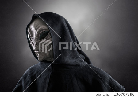 Mysterious humanoid alien at night over dark misty background  130707596