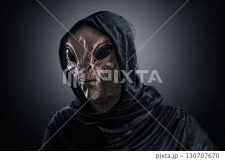 Mysterious humanoid alien at night over dark misty background Mysterious humanoid alien at night over dark misty background 130707670