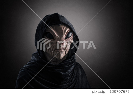 Mysterious humanoid alien at night over dark misty background  130707675