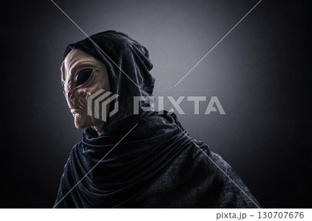 Mysterious humanoid alien at night over dark misty background  130707676