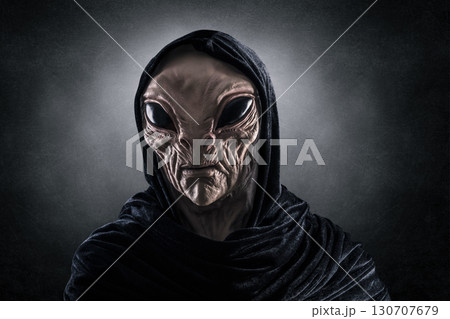 Mysterious humanoid alien at night over dark misty background Mysterious humanoid alien at night over dark misty background 130707679