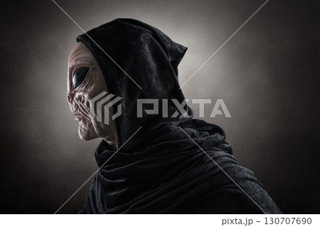 Mysterious humanoid alien at night over dark misty background Mysterious humanoid alien at night over dark misty background 130707690
