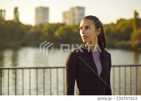 Blurred background of lush greenery and lake woman standing enjoys tranquility of nature city park. Idyllic scene captures essence of city park peaceful retreat amidst bustling city life Green park. Blurred background of lush greenery and lake woman standing enjoys tranquility of nature city park. Idyllic scene captures essence of city park peaceful retreat amidst bustling city life Green park. 130707822