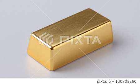 Shiny gold bar on a light gray surface, reflecting light. Investment and wealth concepts. Rich golden hue. Minimalist composition. 130708260