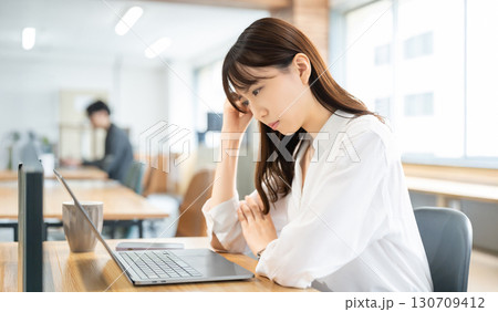 パソコンを使いながら考える女性・ビジネスウーマン 130709412