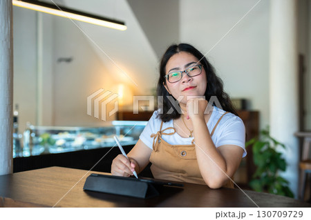Portrait asian freelance people business female wearing glasses stylish hipste Draw or taking note on digital tablet with electronic pen for browsing internet, chatting and blogging in coffee shop. Portrait asian freelance people business female wearing glasses stylish hipste Draw or taking note on digital tablet with electronic pen for browsing internet, chatting and blogging in coffee shop. 130709729