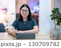 Portrait asian freelance people business female wearing glasses stylish hipster Draw or taking note on digital tablet with electronic pen for browsing internet, chatting and blogging in coffee shop. 130709782