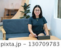 Portrait asian freelance people business female wearing glasses stylish hipster Draw or taking note on digital tablet with electronic pen for browsing internet, chatting and blogging in coffee shop. 130709783
