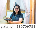Portrait asian freelance people business female wearing glasses stylish hipster Draw or taking note on digital tablet with electronic pen for browsing internet, chatting and blogging in coffee shop. 130709784