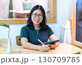 Portrait asian freelance people business female wearing glasses stylish hipster Draw or taking note on digital tablet with electronic pen for browsing internet, chatting and blogging in coffee shop. 130709785