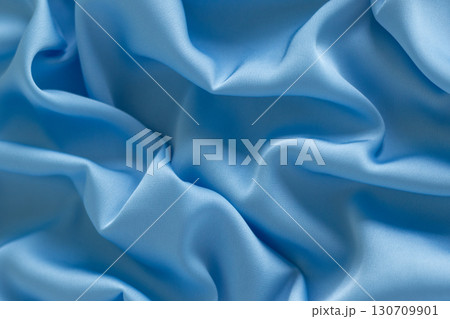 Soft blue fabric with gentle folds creating a vibrant texture 130709901