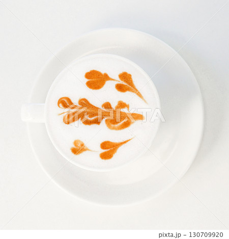 Cup of cappuccino with intricate latte art on a clean white saucer 130709920