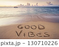 handwritten good vibes on sandy beach 130710226