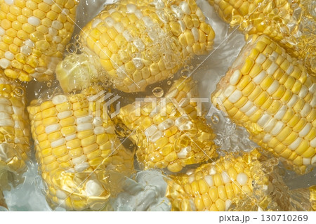 Fresh corn cobs splashing in water top view. 130710269