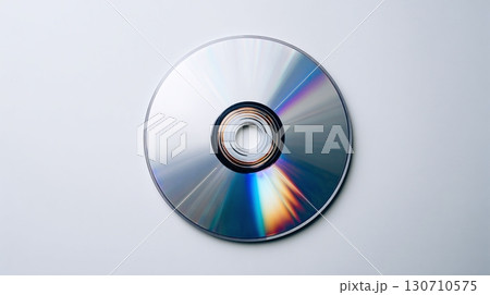 A compact disc featuring a spiral design and iridescent patterns, showcasing the technology of data storage and retrieval on a neutral surface. 130710575