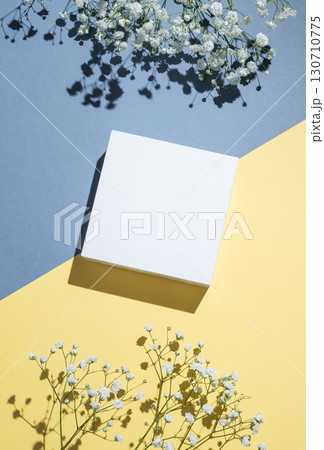 White cube, podium or box with shadow on diagonally divided yellow and blue background 130710775