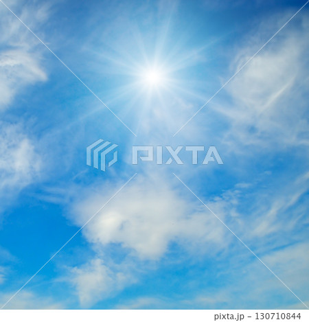 Sun with Rays in a Blue Sky with Clouds 130710844