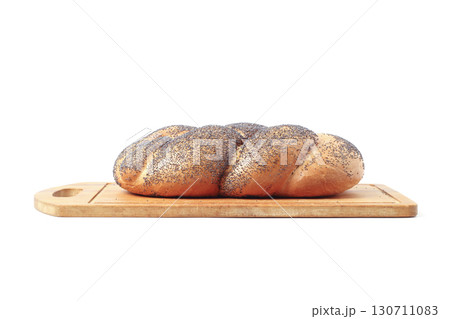Bun with poppy seeds on a kitchen board Bun with poppy seeds on a kitchen board 130711083