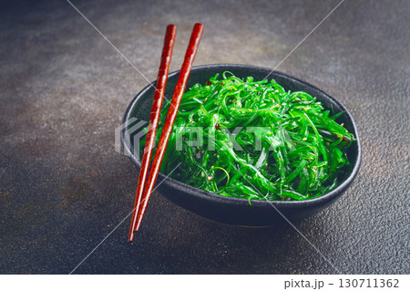 Chuka salad, made from fresh seaweed, with sesame dressing, served in a black bowl, with chopsticks, 130711362