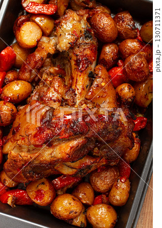 Pork knuckle, baked with vegetables, new potatoes , on a baking sheet, homemade, no people, Pork knuckle, baked with vegetables, new potatoes , on a baking sheet, homemade, no people, 130711371