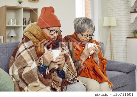 Senior Couple Warm with Tea on the Couch Senior Couple Warm with Tea on the Couch 130711601